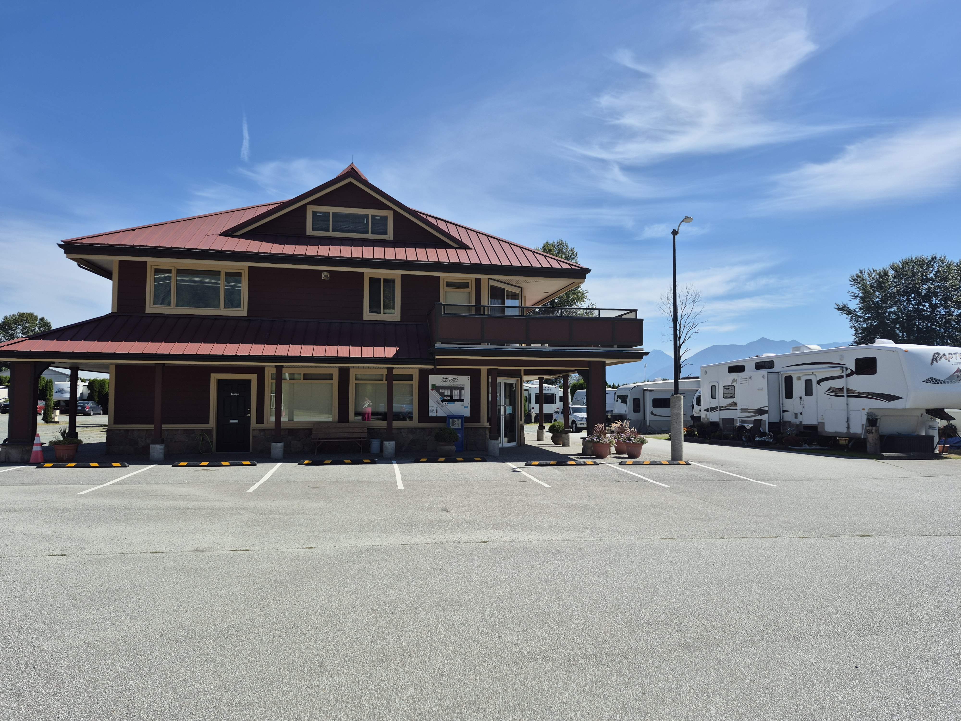 Royalwood RV Park main building with RVs and mountain views